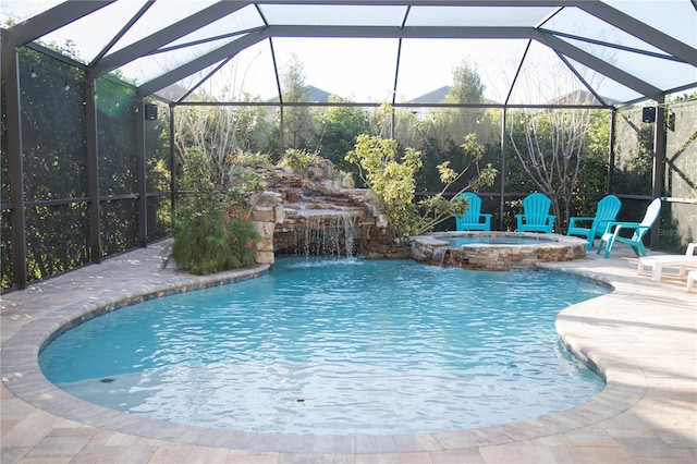 view of pool with a patio area, glass enclosure, and a pool with connected hot tub