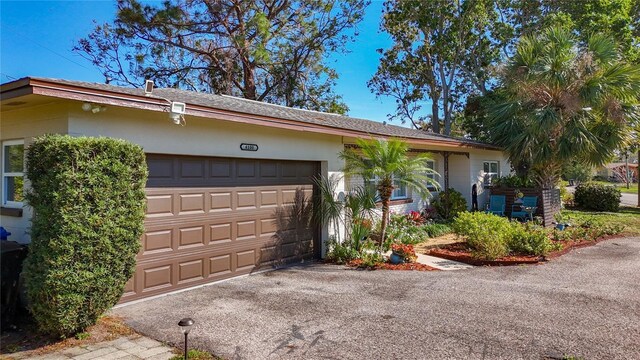 4100 Narvarez Way S, Saint Petersburg, FL 33712 - ranch-style home with a garage, stucco siding, and asphalt driveway