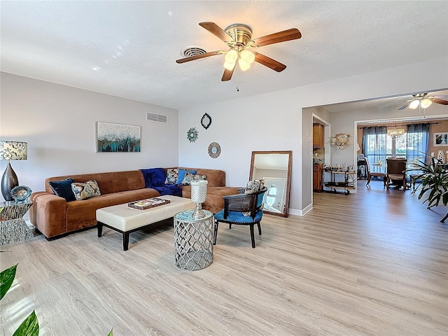 4100 Narvarez Way S, Saint Petersburg, FL 33712 - living area with a ceiling fan, light wood-style flooring, a textured ceiling, and baseboards