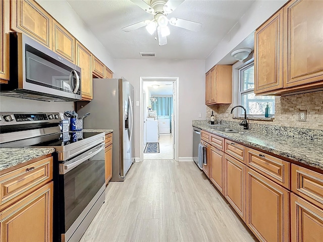 4100 Narvarez Way S, Saint Petersburg, FL 33712 - kitchen featuring stainless steel appliances, a sink, light wood finished floors, decorative backsplash, and a ceiling fan