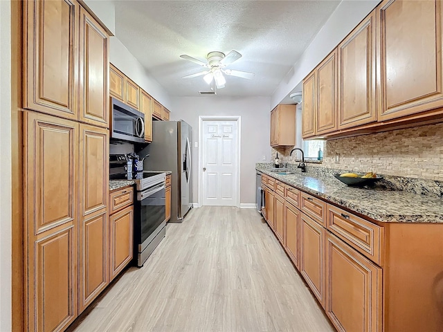 4100 Narvarez Way S, Saint Petersburg, FL 33712 - kitchen with appliances with stainless steel finishes, a sink, backsplash, a ceiling fan, and light wood-style flooring
