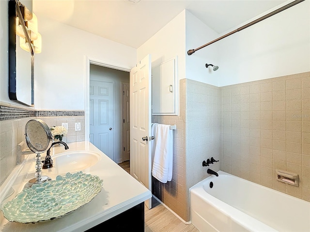 4100 Narvarez Way S, Saint Petersburg, FL 33712 - bathroom with tile walls, vanity, shower / tub combination, a wainscoted wall, and wood finished floors