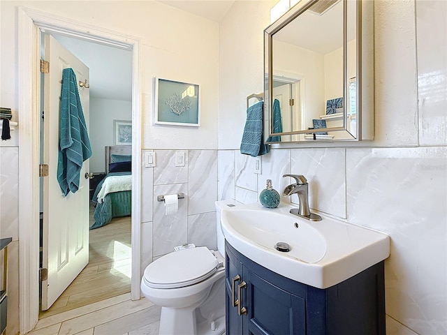 4100 Narvarez Way S, Saint Petersburg, FL 33712 - ensuite bathroom featuring tile walls, vanity, wood finished floors, and toilet