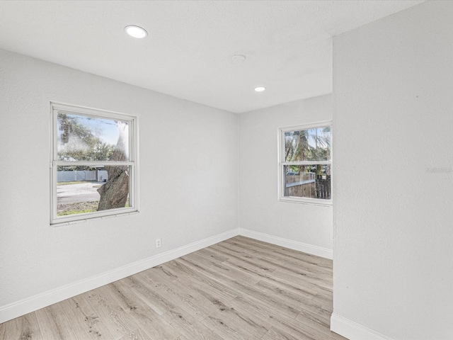 unfurnished room featuring light wood-type flooring, baseboards, and recessed lighting