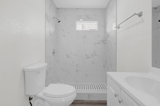 bathroom featuring toilet, a shower stall, and vanity