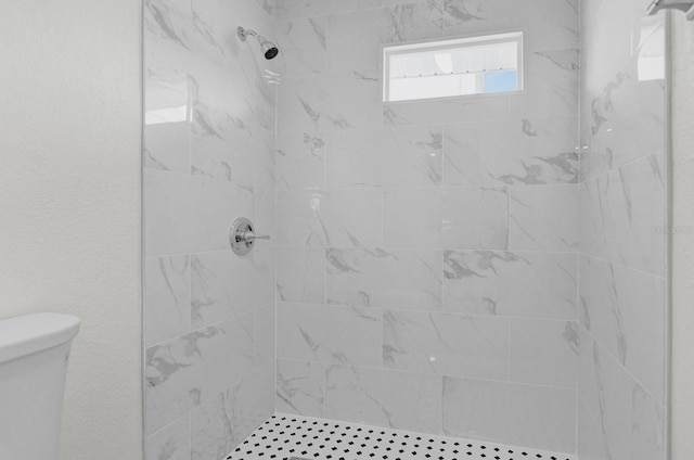 bathroom featuring toilet and tiled shower