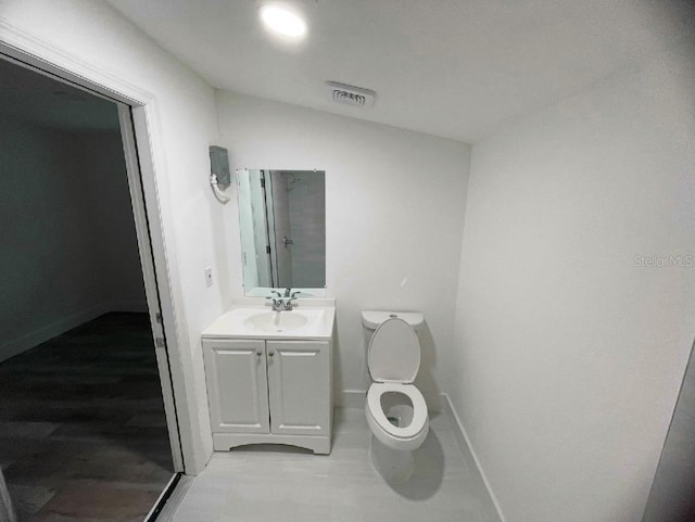 bathroom featuring lofted ceiling, visible vents, toilet, vanity, and baseboards