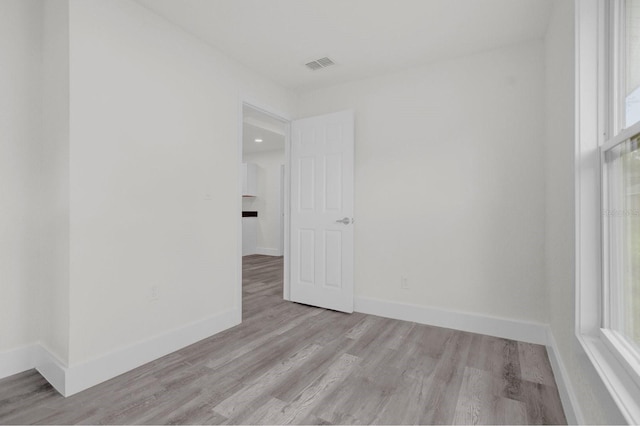 spare room with light wood-style flooring, visible vents, and baseboards