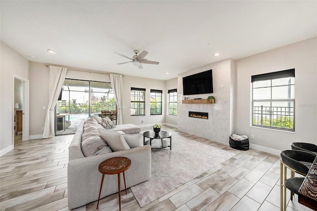 living room featuring plenty of natural light, a fireplace, and baseboards