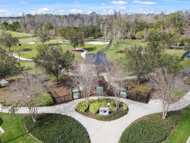 surrounding community with concrete driveway, a yard, and fence