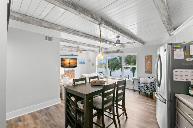 dining area with visible vents, a ceiling fan, wood finished floors, beamed ceiling, and baseboards