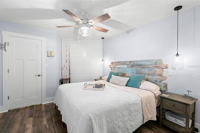 bedroom featuring a ceiling fan, baseboards, and wood finished floors