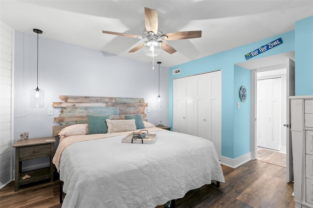 bedroom featuring ceiling fan, dark wood-style flooring, a closet, and baseboards