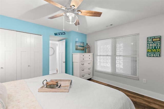 bedroom featuring baseboards, visible vents, a ceiling fan, dark wood-style floors, and a closet