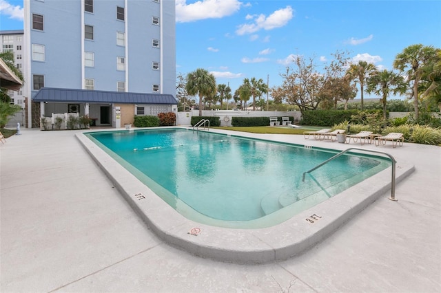 community pool featuring an outbuilding and a patio area