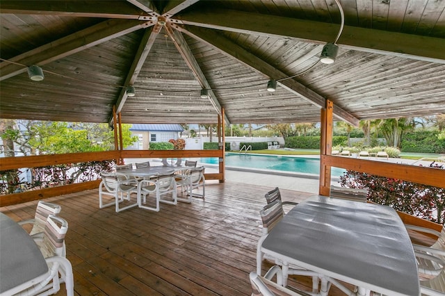 wooden deck featuring a gazebo, outdoor dining space, an outdoor pool, and area for grilling