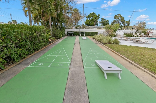 surrounding community with a yard, fence, shuffleboard, and a patio