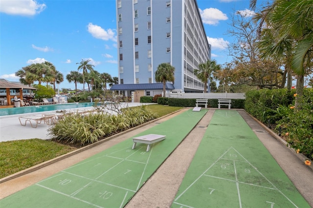 view of community with a swimming pool and shuffleboard