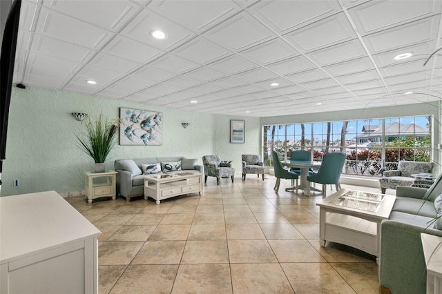 living room with recessed lighting, light tile patterned flooring, and a textured wall