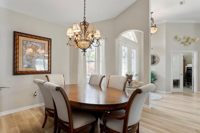 dining room featuring light wood-type flooring, visible vents, and baseboards