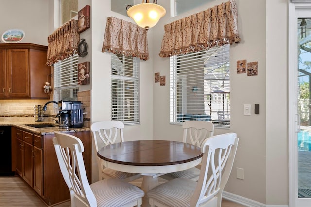 dining space with light wood-style flooring and baseboards