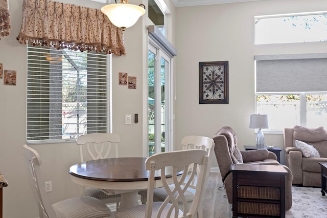 dining space with a healthy amount of sunlight, crown molding, baseboards, and wood finished floors