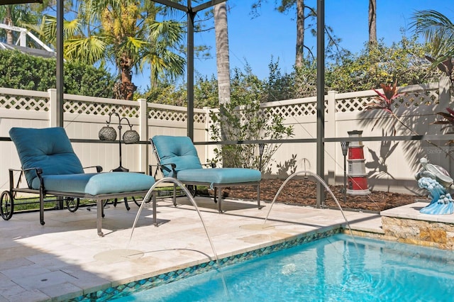 view of swimming pool with glass enclosure, a fenced backyard, a fenced in pool, and a patio