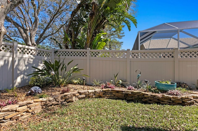 view of yard featuring glass enclosure and a fenced backyard