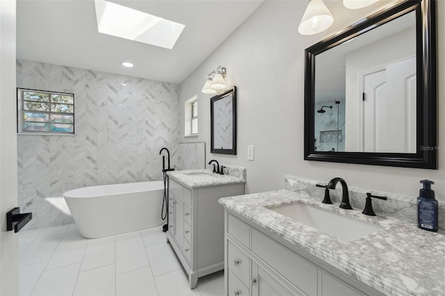 full bath with a freestanding tub, two vanities, a sink, and tile walls