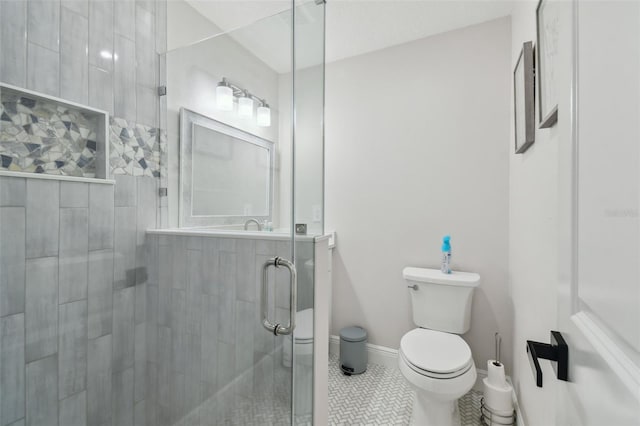 bathroom with toilet, a stall shower, tile patterned flooring, and baseboards