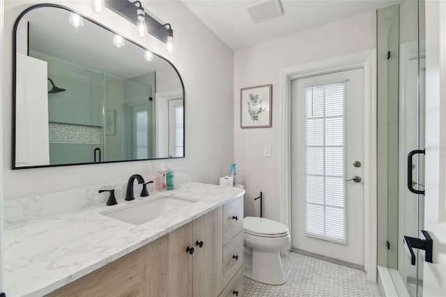 full bathroom with a shower stall, visible vents, vanity, and toilet