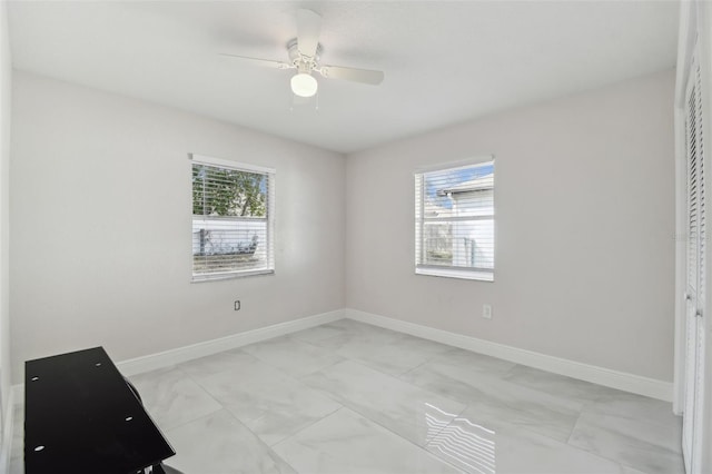 unfurnished room featuring ceiling fan and baseboards