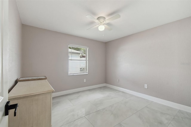 spare room with ceiling fan and baseboards