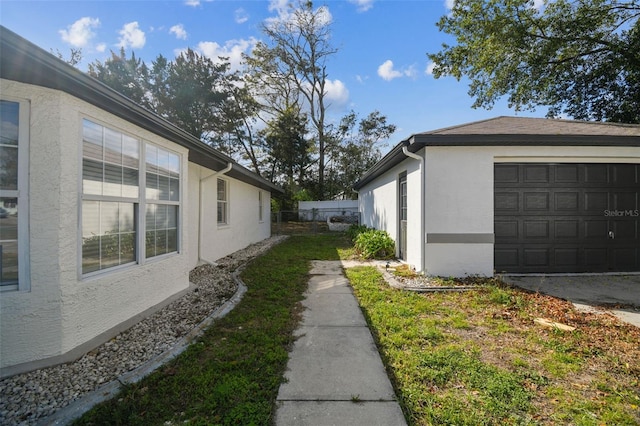 view of side of property with a garage and stucco siding