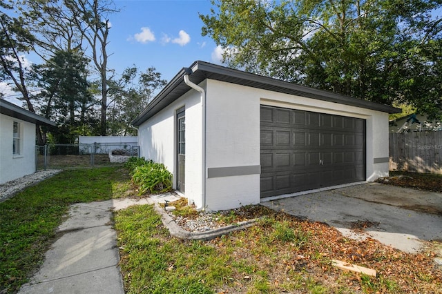 detached garage featuring fence