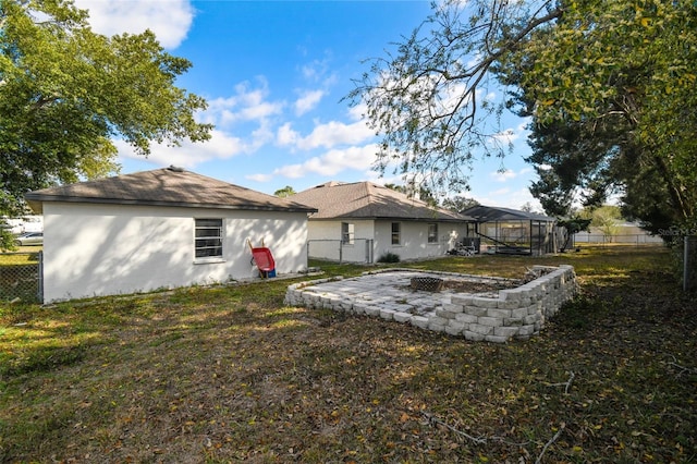 back of house with a yard, fence, and stucco siding