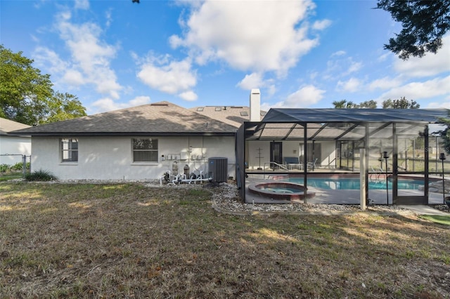 back of property featuring a chimney, stucco siding, central air condition unit, a lawn, and a lanai