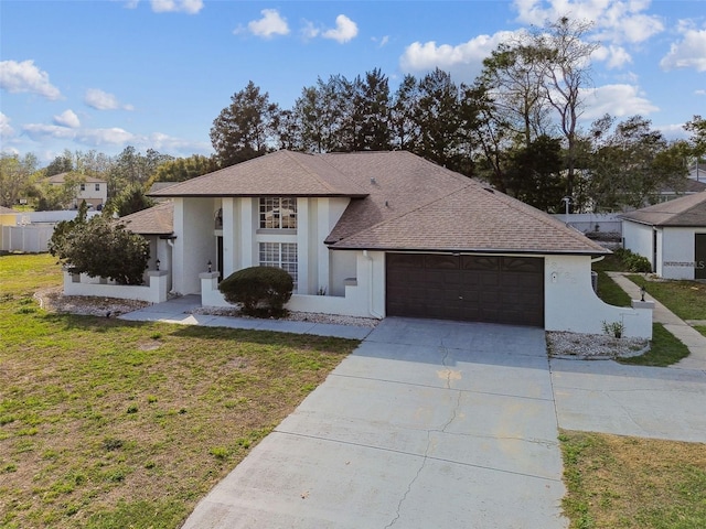 view of front of home featuring stucco siding, a shingled roof, concrete driveway, an attached garage, and a front yard