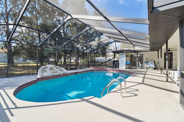 outdoor pool featuring a lanai, a jacuzzi, fence, a ceiling fan, and a patio area