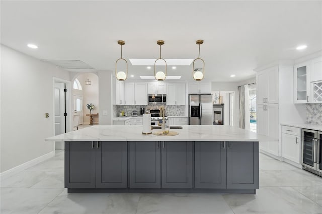 kitchen featuring stainless steel appliances, a large island, and white cabinets