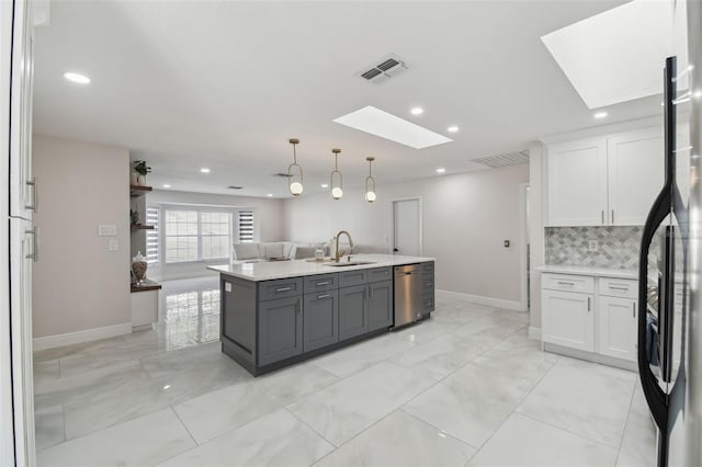 kitchen with open floor plan, light countertops, a sink, and white cabinets