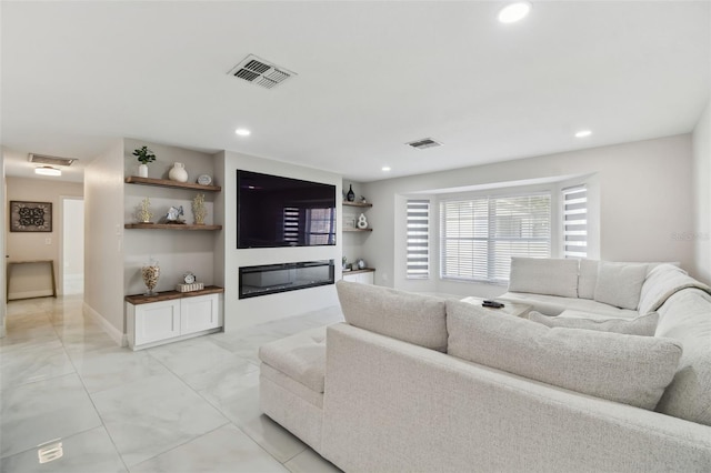 living area with recessed lighting, visible vents, and a glass covered fireplace