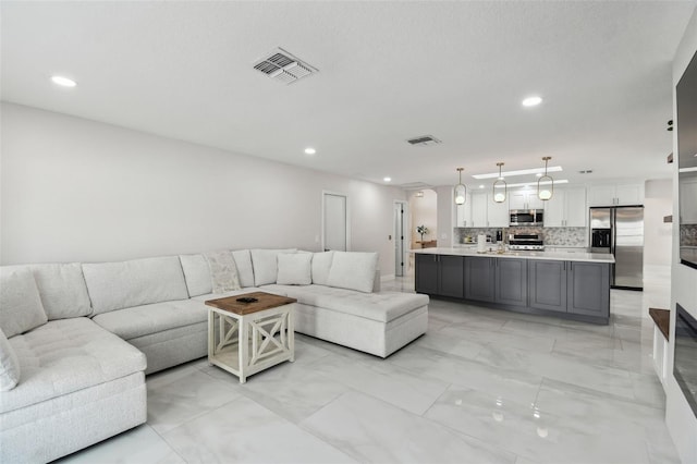 living area with marble finish floor, visible vents, and recessed lighting