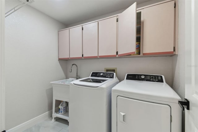 clothes washing area featuring cabinet space, independent washer and dryer, and baseboards