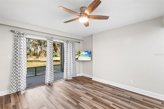 spare room featuring a ceiling fan, baseboards, and wood finished floors