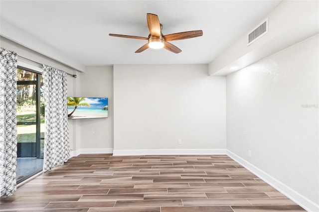 unfurnished room with baseboards, wood tiled floor, visible vents, and ceiling fan