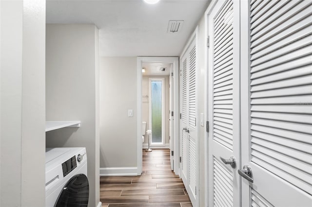 laundry room with laundry area, baseboards, washer / clothes dryer, and wood finished floors