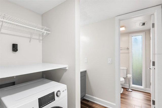 laundry area featuring laundry area, wood finished floors, visible vents, baseboards, and washer / dryer