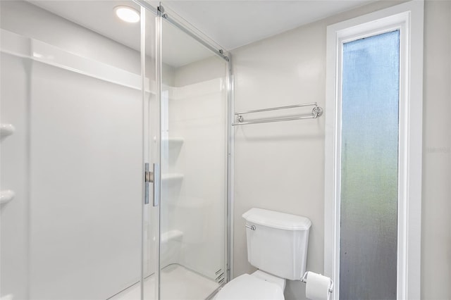 bathroom featuring toilet and a stall shower