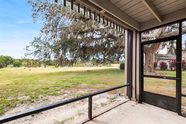 unfurnished sunroom featuring beamed ceiling